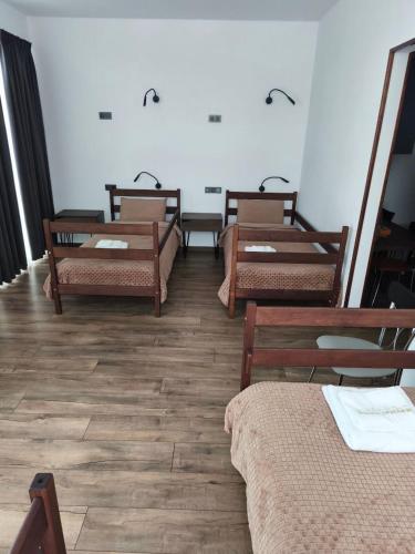 a room with four wooden beds and a table at Mayster Home in Chernivtsi