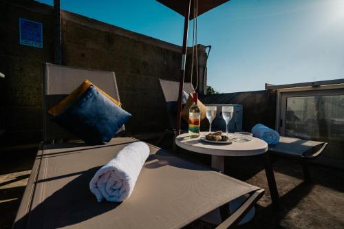 a patio with a table and chairs and an umbrella at Mohba Townhouse, Private Roof Top Jacuzzi, Garden, BBQ by Haven & Keys Malta in Xagħra