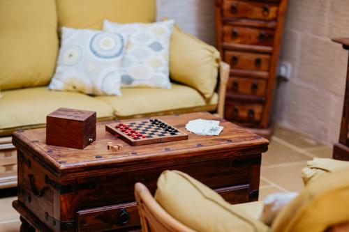 a living room with a chess board on a table at Mohba Townhouse, Private Roof Top Jacuzzi, Garden, BBQ by Haven & Keys Malta in Xagħra