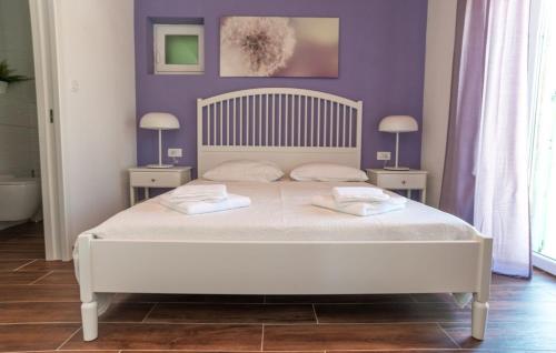 a bedroom with a large white bed with two tables at House Victoria 2 by Villas Guide in Nerezine