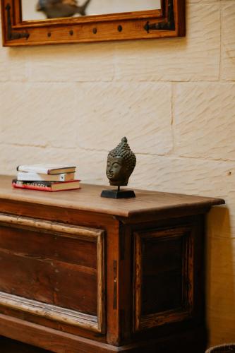 a table with a statue sitting on top of it at Mohba Townhouse, Private Roof Top Jacuzzi, Garden, BBQ by Haven & Keys Malta in Xagħra