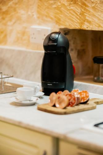 a black appliance sitting on a kitchen counter with a plate of food at Mohba Townhouse, Private Roof Top Jacuzzi, Garden, BBQ by Haven & Keys Malta in Xagħra
