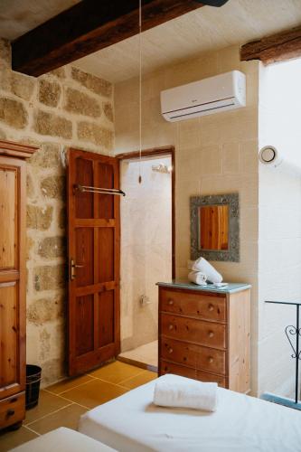 a bathroom with a wooden door and a sink at Mohba Townhouse, Private Roof Top Jacuzzi, Garden, BBQ by Haven & Keys Malta in Xagħra