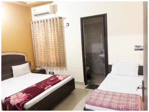 two beds in a room with a shower and a bathroom at HOTEL G!S Paradise Amritsar - Provided Fully Air Conditioned & Well Decorated Rooms - Free Parking And Free Wi-fi Facility - A Premium Hotel In Amritsar in Amritsar