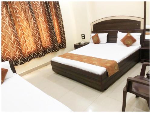 a bedroom with two beds and a large window at HOTEL G!S Paradise Amritsar - Provided Fully Air Conditioned & Well Decorated Rooms - Free Parking And Free Wi-fi Facility - A Premium Hotel In Amritsar in Amritsar