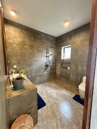 a bathroom with a toilet and a sink at Enchanted Pool Bungalows Siem Reap, right near the Wake Park in Phumĭ Kruŏs