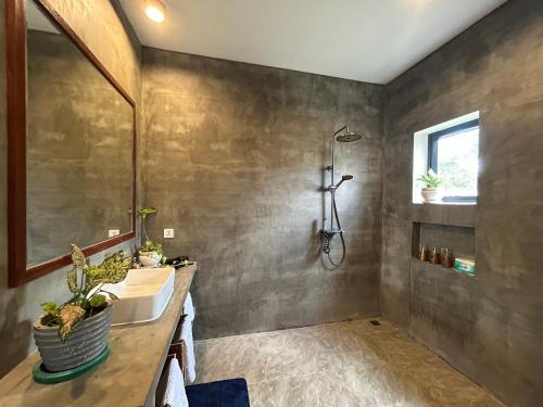 a bathroom with a sink and a shower at Enchanted Pool Bungalows Siem Reap, right near the Wake Park in Phumĭ Kruŏs