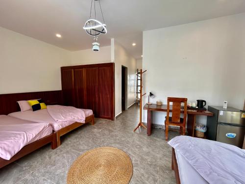 a bedroom with two beds and a desk and a table at Enchanted Pool Bungalows Siem Reap, right near the Wake Park in Phumĭ Kruŏs
