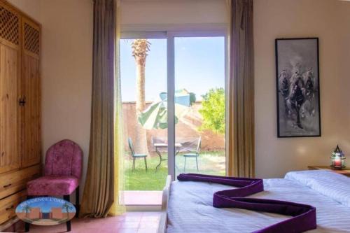 a bedroom with two beds and a large window at Villa Essalah & Spa in Marrakech