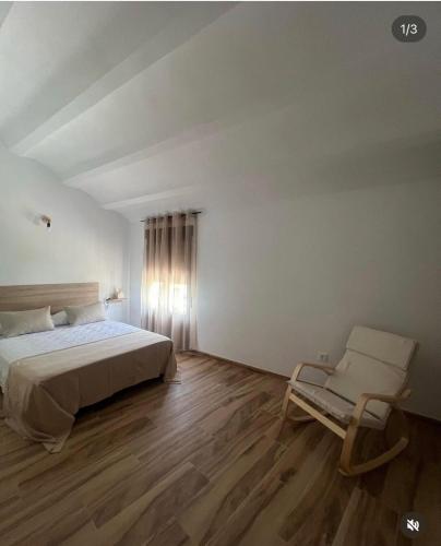 a bedroom with a bed and a chair at Nuestro Refugio Rural in Cortijos Nuevos