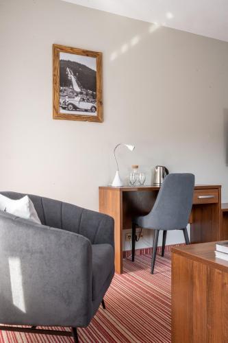 a living room with a couch and a desk at Hotel Willa Pod Skocznią in Zakopane