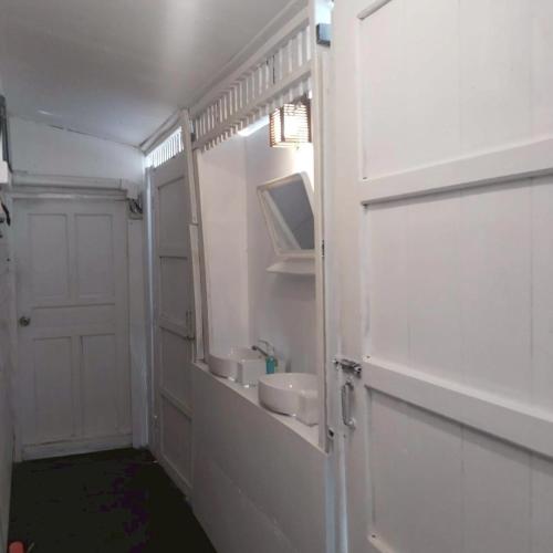 a white bathroom with a sink and a mirror at Aran hostel Spa&Cafe Riverside That Phanom in Amphoe That Phanom