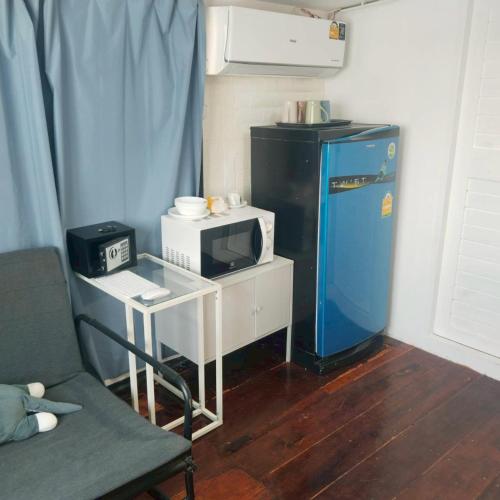 a small kitchen with a microwave and a small table at Aran hostel Spa&Cafe Riverside That Phanom in Amphoe That Phanom