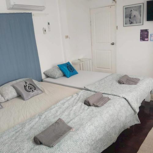 two twin beds in a room with towels on them at Aran hostel Spa&Cafe Riverside That Phanom in Amphoe That Phanom