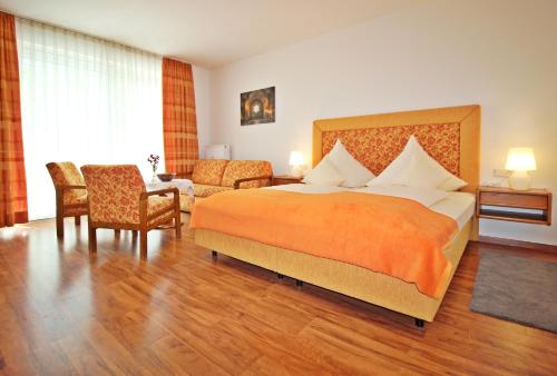 a hotel room with a bed and a chair at Hotel Garni Lichtquelle in Bad Füssing