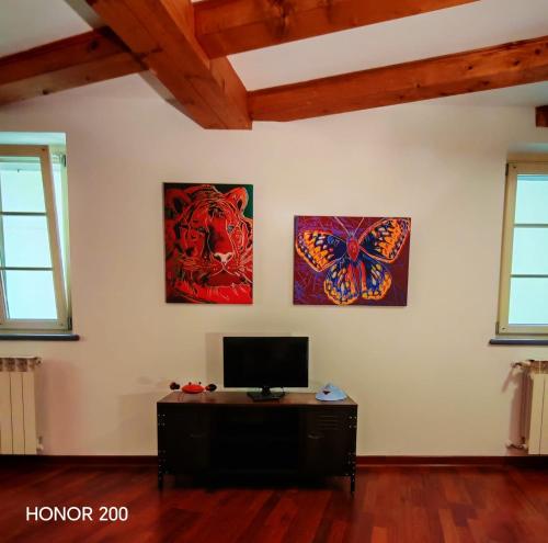 a room with two paintings on the wall and a television at Home Art & Design in Trieste