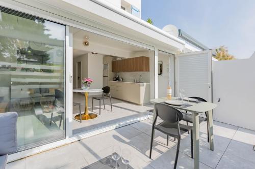 un patio avec une table et des chaises et une cuisine dans l'établissement Villa Luxe Port Nature 2, au Cap d'Agde