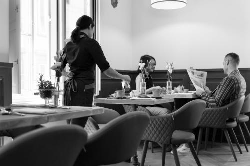 a woman standing next to a man sitting at a table at Corte Calzaiuoli Elegant Suites in Florence