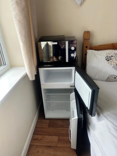 a small refrigerator in a room next to a bed at Clarendon Lodge - accommodation only in Skegness