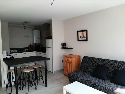 un salon avec un canapé et une table et une cuisine dans l'établissement Appartement Confortable en Plein Centre de Saint-Jean-de-Luz, à Deux Pas de la Plage et des Commerces - FR-1-239-586, à Saint-Jean-de-Luz