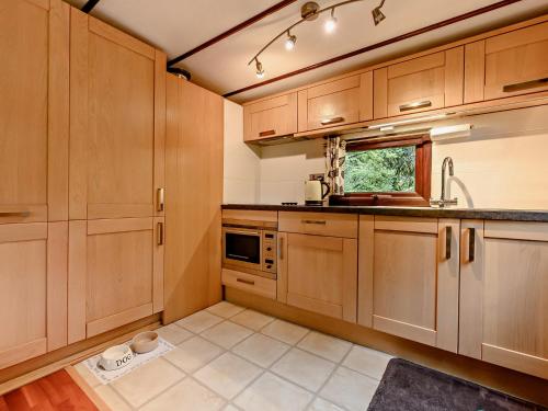 a kitchen with wooden cabinets and a sink at 2 Bed in Ambleside 75731 in Grasmere