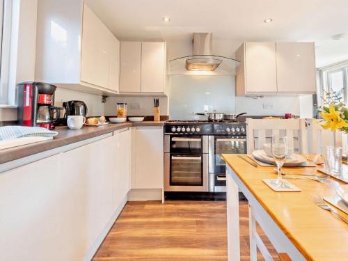 a kitchen with white cabinets and a wooden counter top at 2 Bed in Aberaeron 94044 in Henfynyw Upper