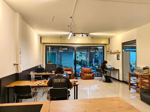 拜县TIMN Hostel Female Only的坐在房间里桌子上的人