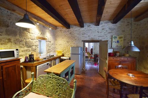 une cuisine avec une table et une salle à manger dans l'établissement Maison en pierre à Laroque-Timbaut - Clévacances 3 clés, à Laroque-Timbaut
