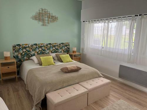 a bedroom with a large bed with yellow pillows at Appartement de charme avec piscine au cœur du Pays Basque - FR-1-239-795 in Urt