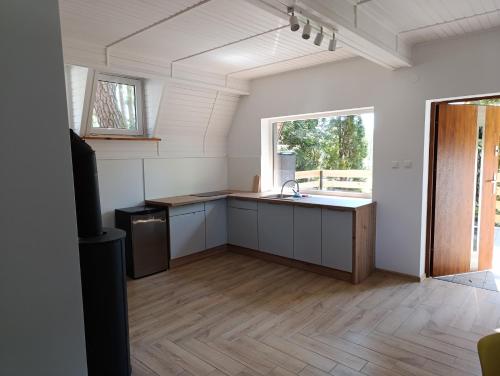 an empty kitchen with a sink and a window at Domek Chatka Czubatka in Bocheniec