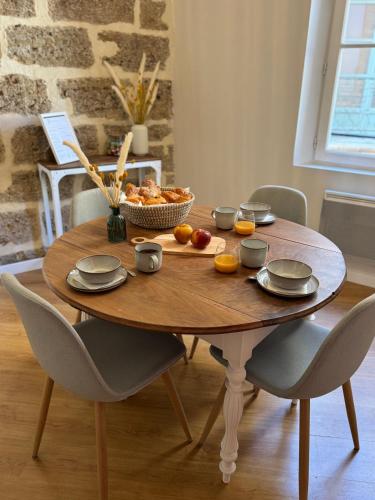 - une table en bois avec un bol de fruits dans l'établissement ExVoto - Appartement de charme - Centre historique, à Pézenas