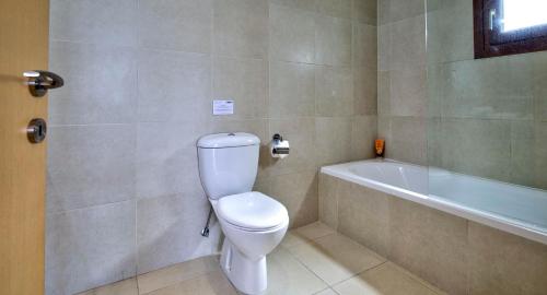 a bathroom with a toilet and a bath tub at Beautiful Sea and Sunset Views from Apartment CE13, Theseus Village, Aphrodite Hills in Kouklia