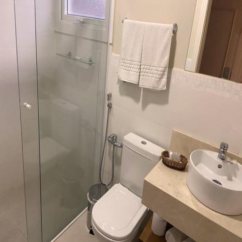 a bathroom with a shower and a toilet and a sink at Hotel Chateau in Campos do Jordão