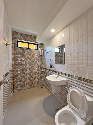a bathroom with a toilet and a sink at Phuiyara Resort in Nakhon Nayok