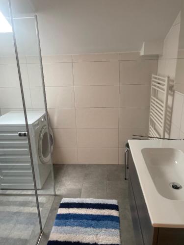 a bathroom with a sink and a washing machine at Haus Hubertus in Fusch an der Glocknerstraße