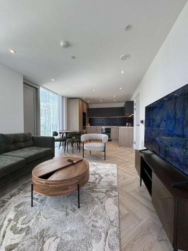 a living room with a couch and a large tv at The Banks - Private Luxury 2-Bed Flat Manchester Central in Manchester