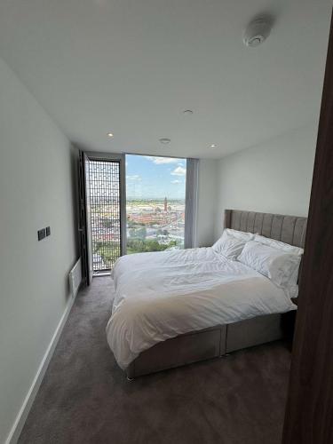 a bedroom with a large bed with a large window at The Banks - Private Luxury 2-Bed Flat Manchester Central in Manchester