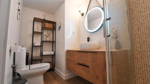 a bathroom with a sink and a toilet and a mirror at SeaHomes Vacations - Seafront Mediterranean Ap & PKG in Blanes