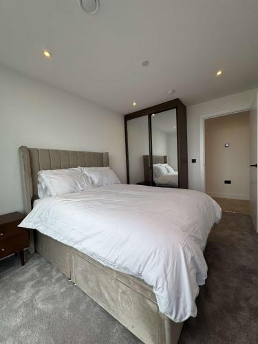 a bedroom with a large bed with white sheets at The Banks - Private Luxury 2-Bed Flat Manchester Central in Manchester