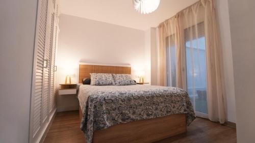 a bedroom with a bed and a large window at SeaHomes Vacations - Seafront Mediterranean Ap & PKG in Blanes