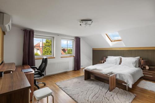 The Teplice Aqua Villa by Aura Luxury Collection في تبليتسه: غرفة نوم مع سرير كبير ومكتب ومكتب