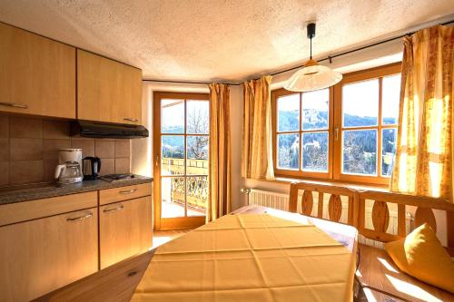 a kitchen with a table and a large window at Ferienhof Almfrieden in Balderschwang