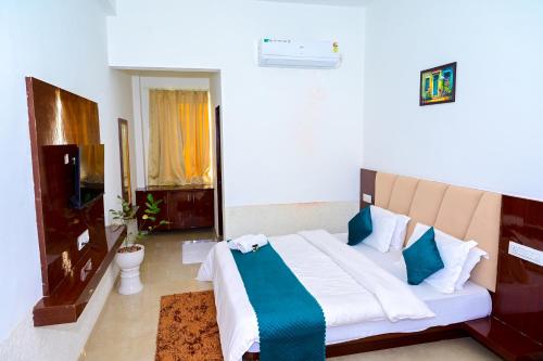 a bedroom with a large bed with blue and white sheets at Hariom Tatsat Retreat in Pushkar