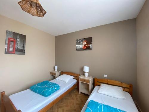 - 2 lits dans une petite chambre avec 2 photos sur le mur dans l'établissement Maison rustique au centre-ville, proche plage, avec jardin et 3 chambres ! - FR-1-22-223, à La Tranche-sur-Mer