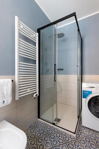 a glass shower in a bathroom with a washing machine at Freshwater Pirates SUITES in Gaeta