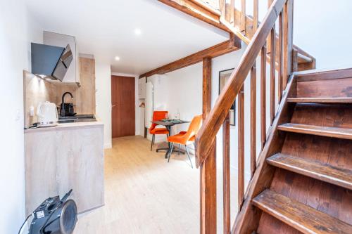 une chambre avec un escalier et une cuisine avec une table dans l'établissement Studio TANAGA, à Annecy