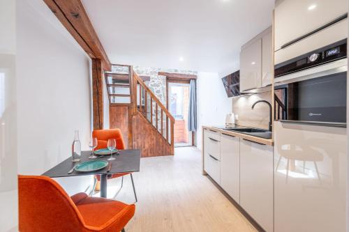 une cuisine avec une table et des chaises dans une pièce dans l'établissement Studio TANAGA, à Annecy