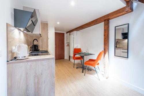 une cuisine et une salle à manger avec une table et des chaises dans l'établissement Studio TANAGA, à Annecy