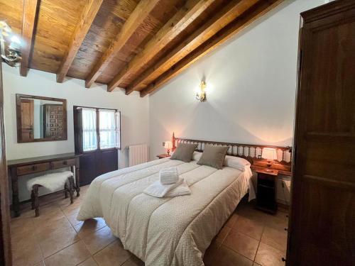 a bedroom with a large bed and a wooden ceiling at Apartamentos Santillana - Mijares 3000 in Mijares