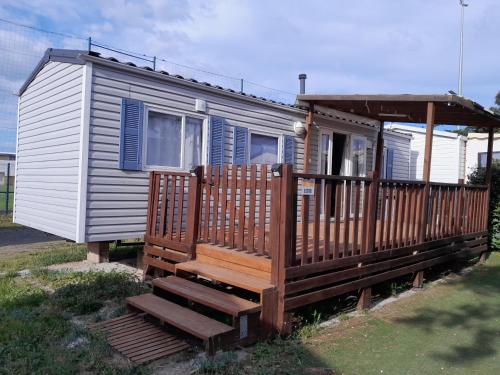 une petite maison avec un porche et une terrasse dans l'établissement Mobilhome tout confort, à Port-la-Nouvelle